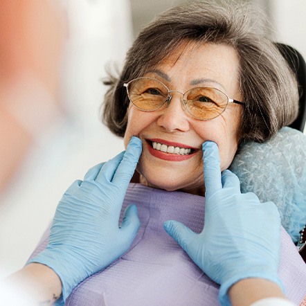 Dentist looking at patient's smile in treatment chair