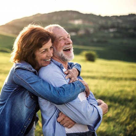 Couple embracing and smiling outdoors