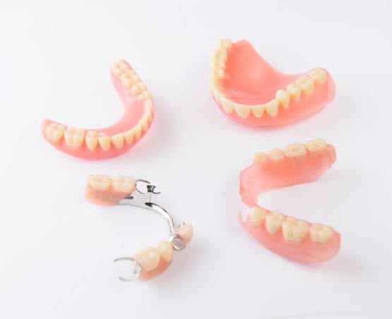 Full and partial dentures arranged on white background