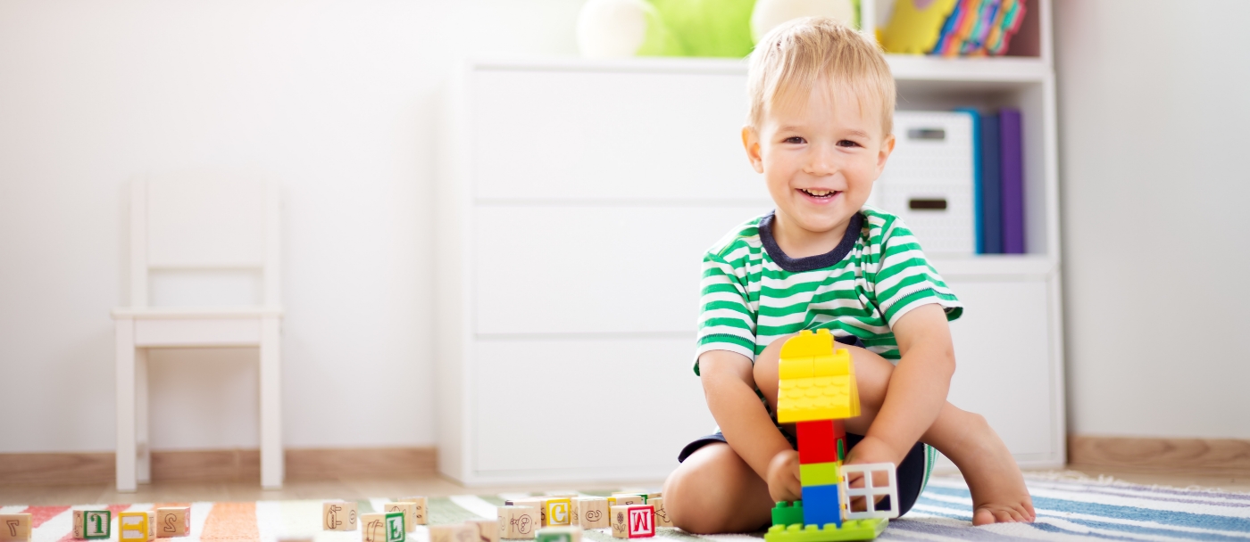 Young boy playing with building block toys on the floor