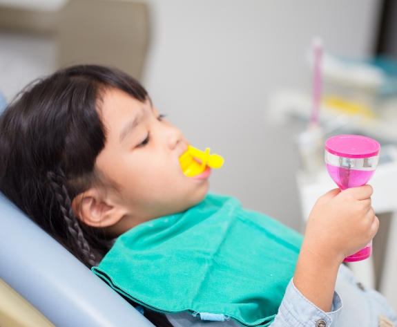 Young girl getting fluoride treatment during dental checkup